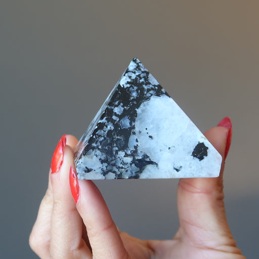 hand holding moonstone tourmaline pyramid