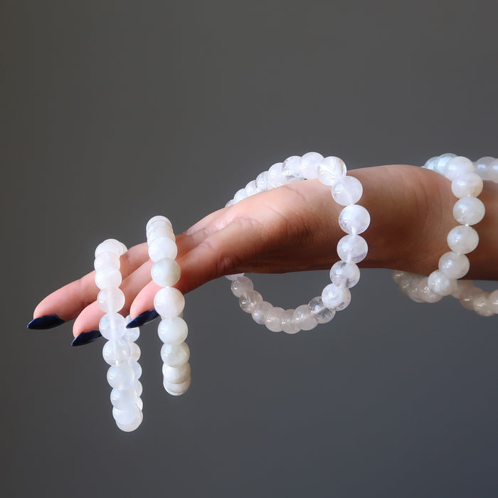 hand holding white rainbow moonstone beaded stretch bracelets