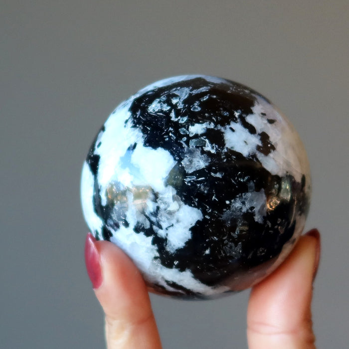 hand holding moonstone tourmaline sphere