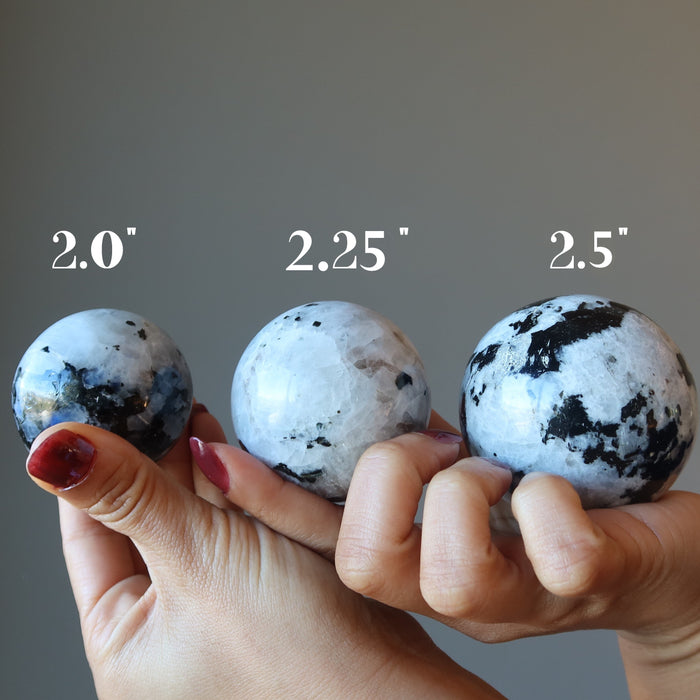 three  moonstone tourmaline spheres of varying sizes