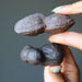 hands holding brown moqui marble clusters
