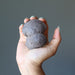 hand holding brown moqui marble cluster