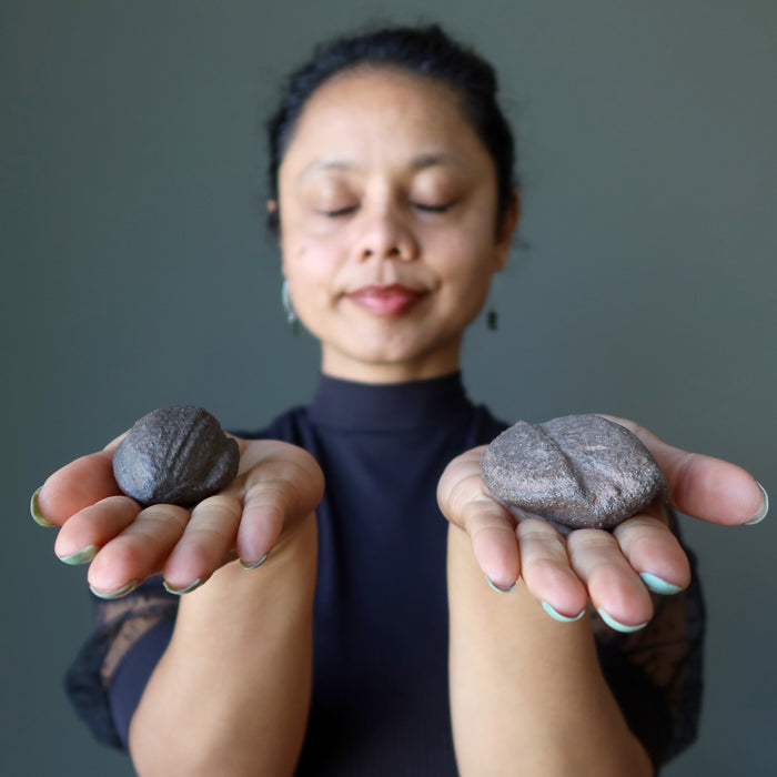 woman holding a natural moqui stones and meditating