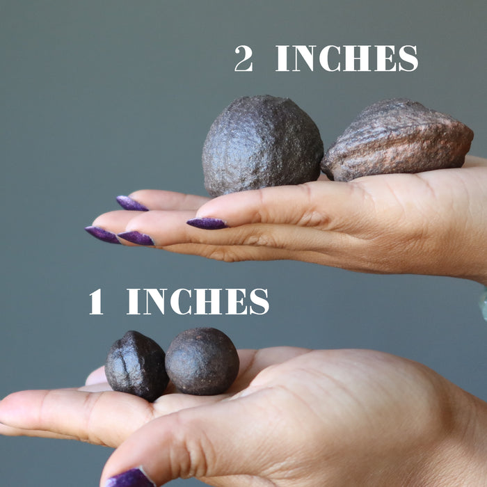 hands with 1 inch and 2 inch pair of moqui marbles
