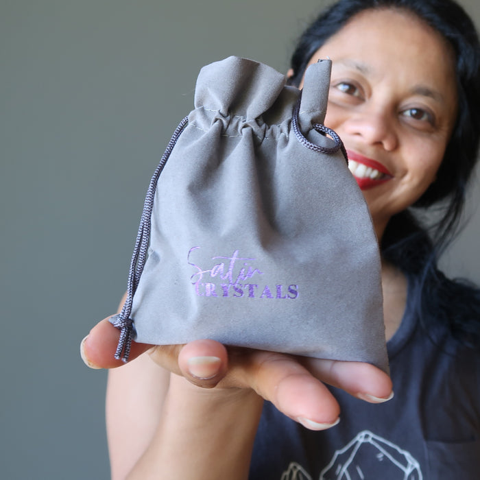 sheila of satin crystals holding out a pouch