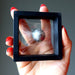 hand holding silver muonionalusta meteorite sphere in zero gravity case