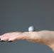 hand holding silver muonionalusta meteorite sphere 