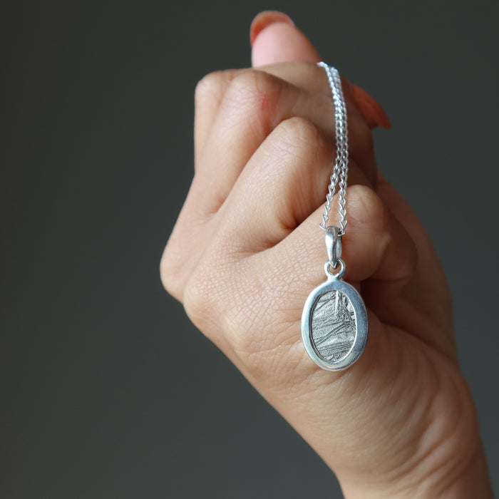 hand holding muonionalusta necklace, showing the back