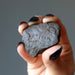 hand holding brown rocky nantan meteorite