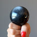 hand holding silver sheen obsidian sphere