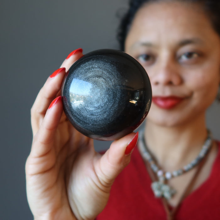 sheila of satin crystals gazing at a silver sheen obsidian sphere