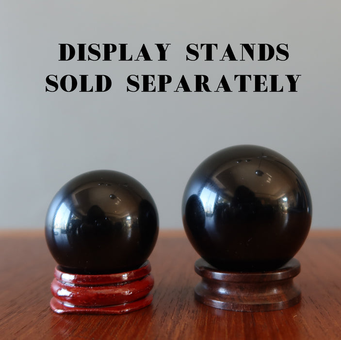 two black obsidian spheres on wood stands