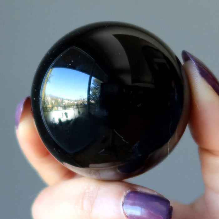 hand holding black obsidian sphere