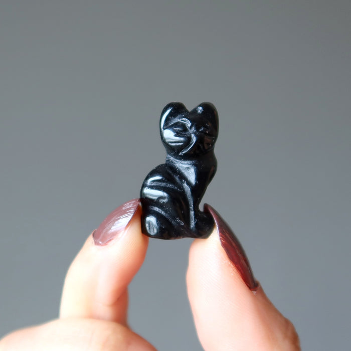 fingers holding a 1" Black Obsidian Cat