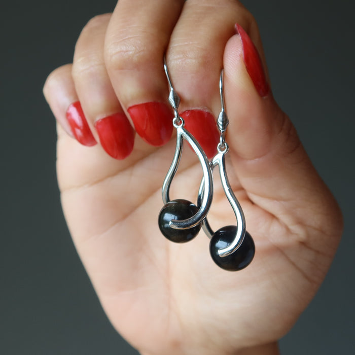 hand holding gold sheen obsidian earrings