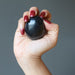 hand holding black obsidian egg
