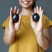 hands holding black obsidian eggs in each palm