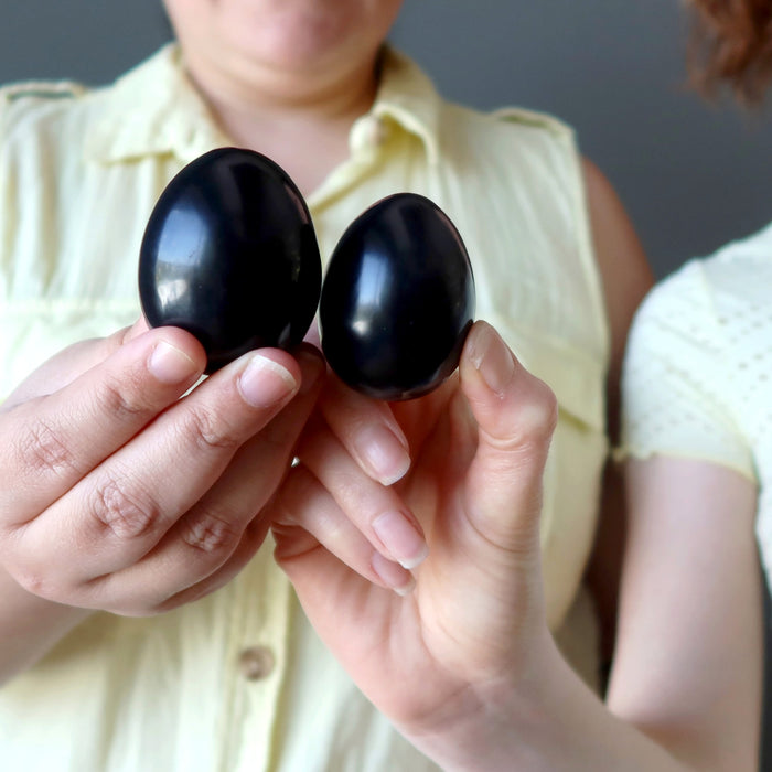 two girls holding black obsidian eggs