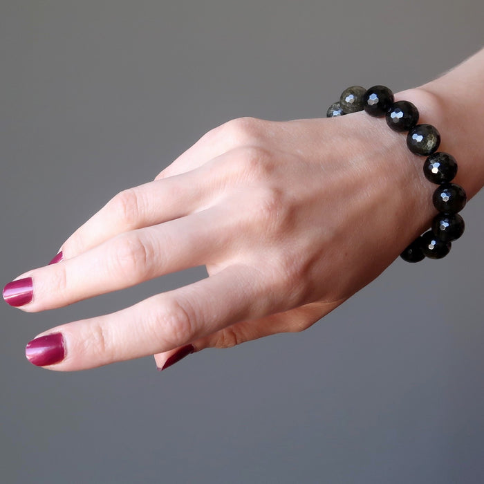 female hand modeling faceted gold sheen obsidian bracelet