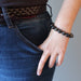 female hand in jeans pocket modeling faceted gold sheen obsidian bracelet