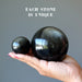 two different size Gold Sheen Obsidian Spheres on the model palm