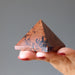 hand holding mahogany obsidian pyramid
