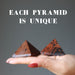 hand holding mahogany obsidian pyramids