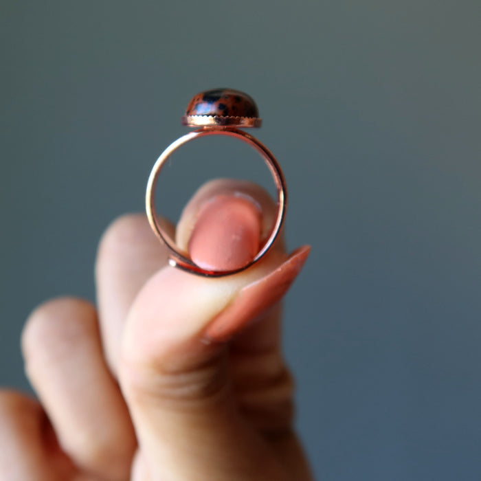 hand holding mahogany obsidian oval in copper adjustable ring 