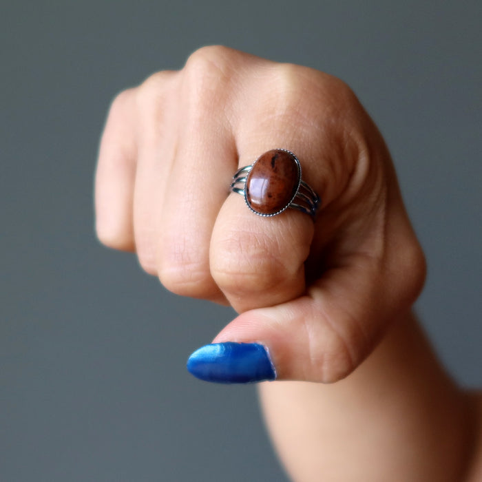 hand wearing mahogany obsidian oval in gunmetal adjustable ring