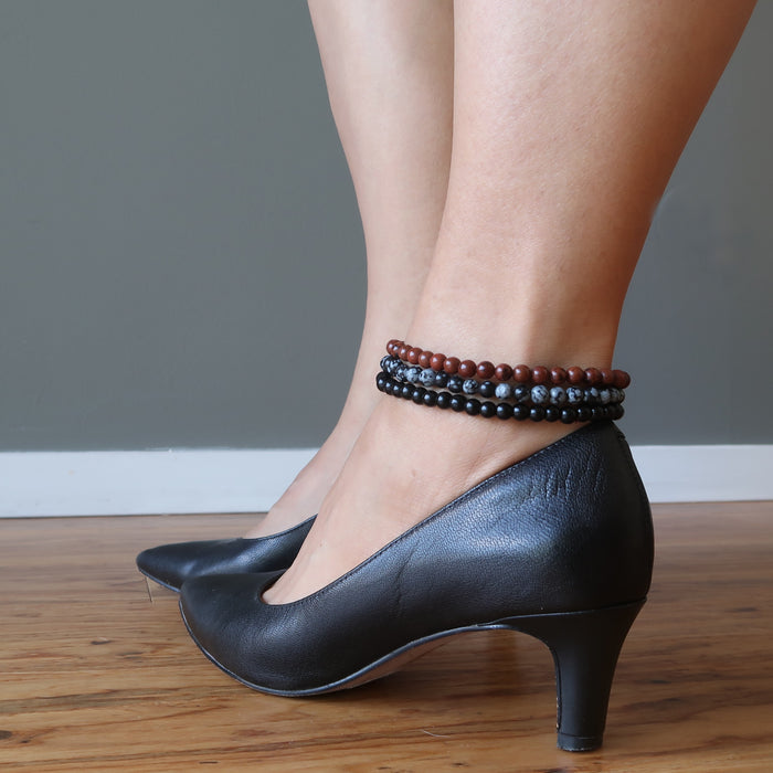 mahogany, snowflake and black obsidian anklets stacked on ankle in black heels