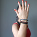 a lady models the obsidian bracelet three piece set on her wrist