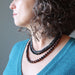 woman wearing triple strand obsidian necklace