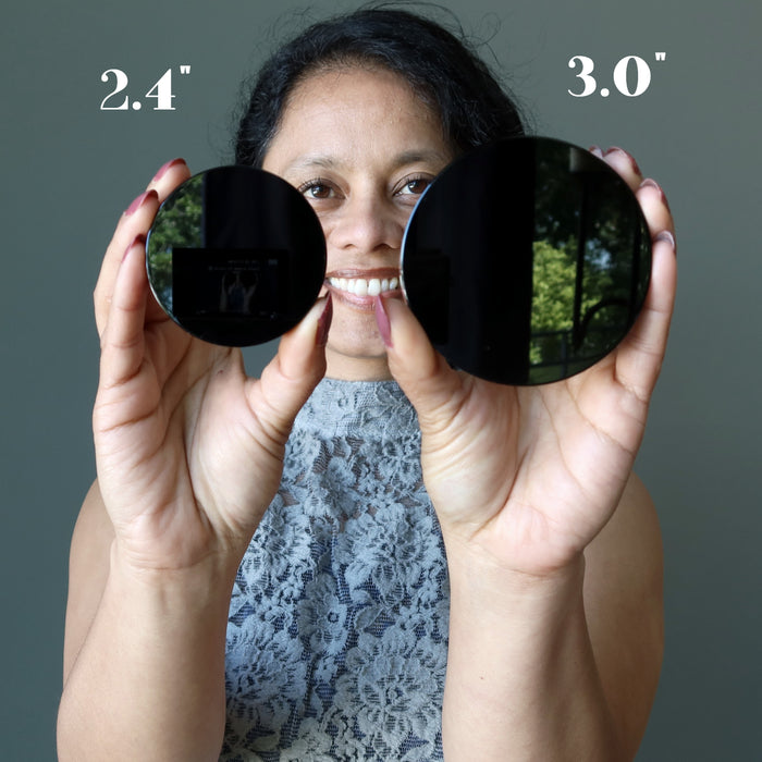 woman holding two obsidian circles