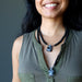 woman wearing two lengths of snowflake obsidian turtle necklaces