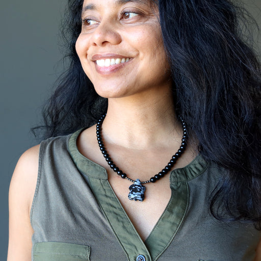 woman wearing snowflake obsidian turtle necklace