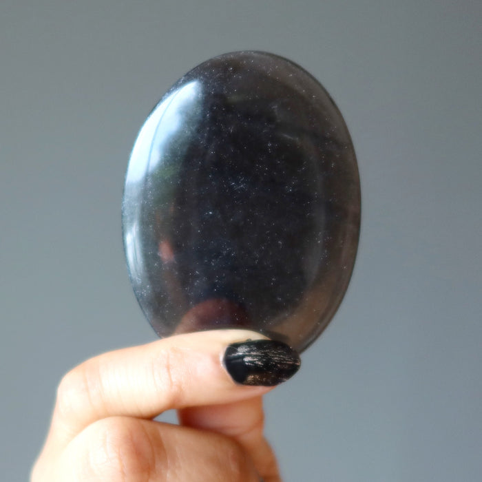 hand holding midnight lace obsidian oval stone