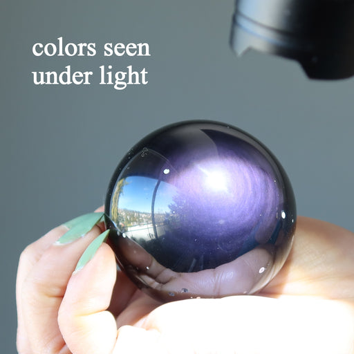 purple obsidian sphere under flashlight