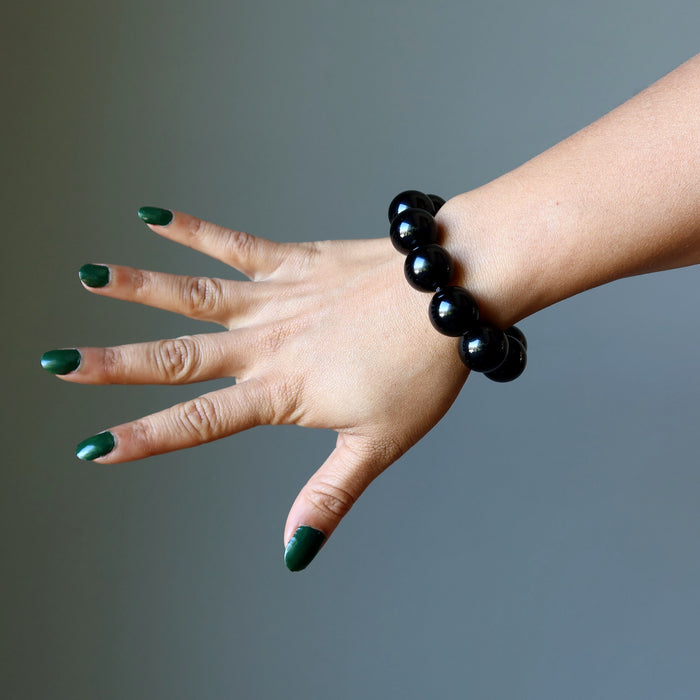 hand wearing rainbow obsidian beaded stretch bracelet