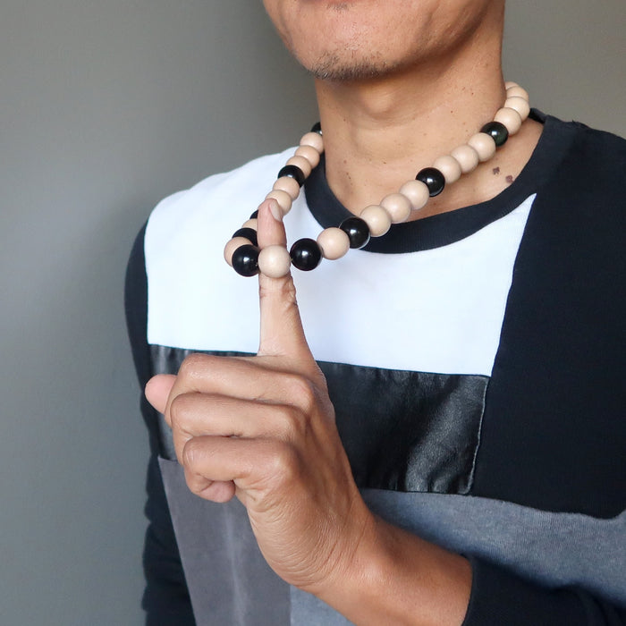 man wearing rainbow obsidian and wood necklace