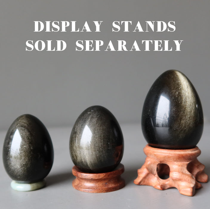 three sheen obsidian eggs on display stands