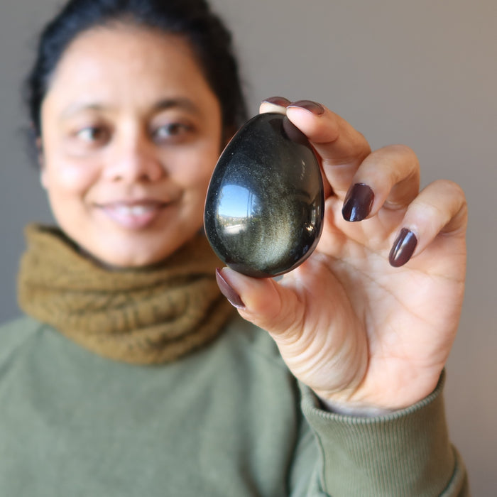 woman holding sheen obsidian egg