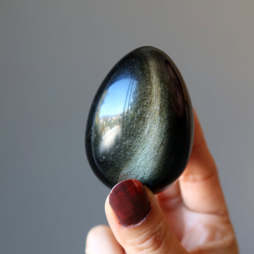 hand holding sheen obsidian egg