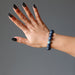 female hand modeling  round spiderweb obsidian stretch bracelet