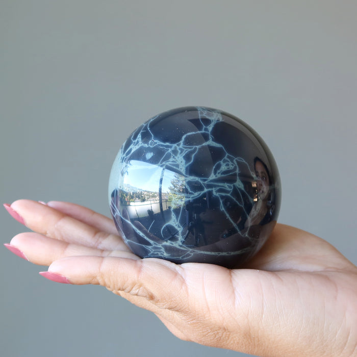Spiderweb Obsidian Sphere on the palm