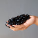 hand holding 43 black obsidian tumbled stones