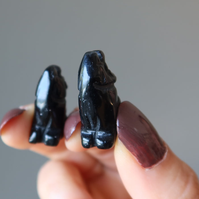 holding two 1" Black Obsidian Wolves