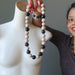 sheila of satin crystals holding a rainbow obsidian necklace