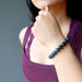 hand on chin wearing matte and polished glossy beaded round black onyx stretch bracelet