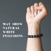fist wearing matte and polished glossy beaded round black onyx stretch bracelet that may show natural white inclusions