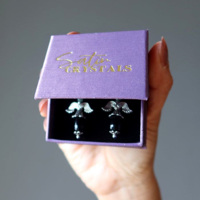 hand holding satin crystals gift box with onyx earrings